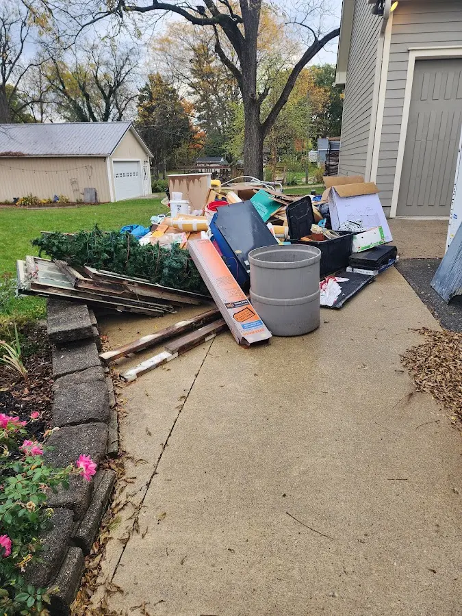Dumpster being loaded with debris for 12 Yard Dumpster Rental in Maple Grove